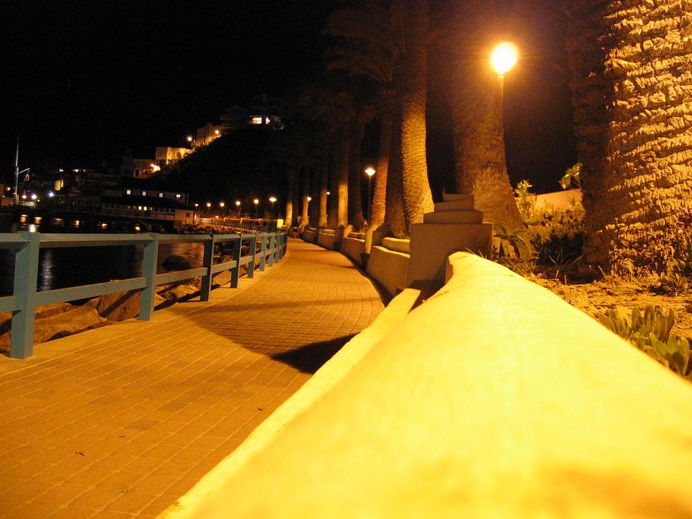 The lamp‑lit harbor walkway to the Casino at night
